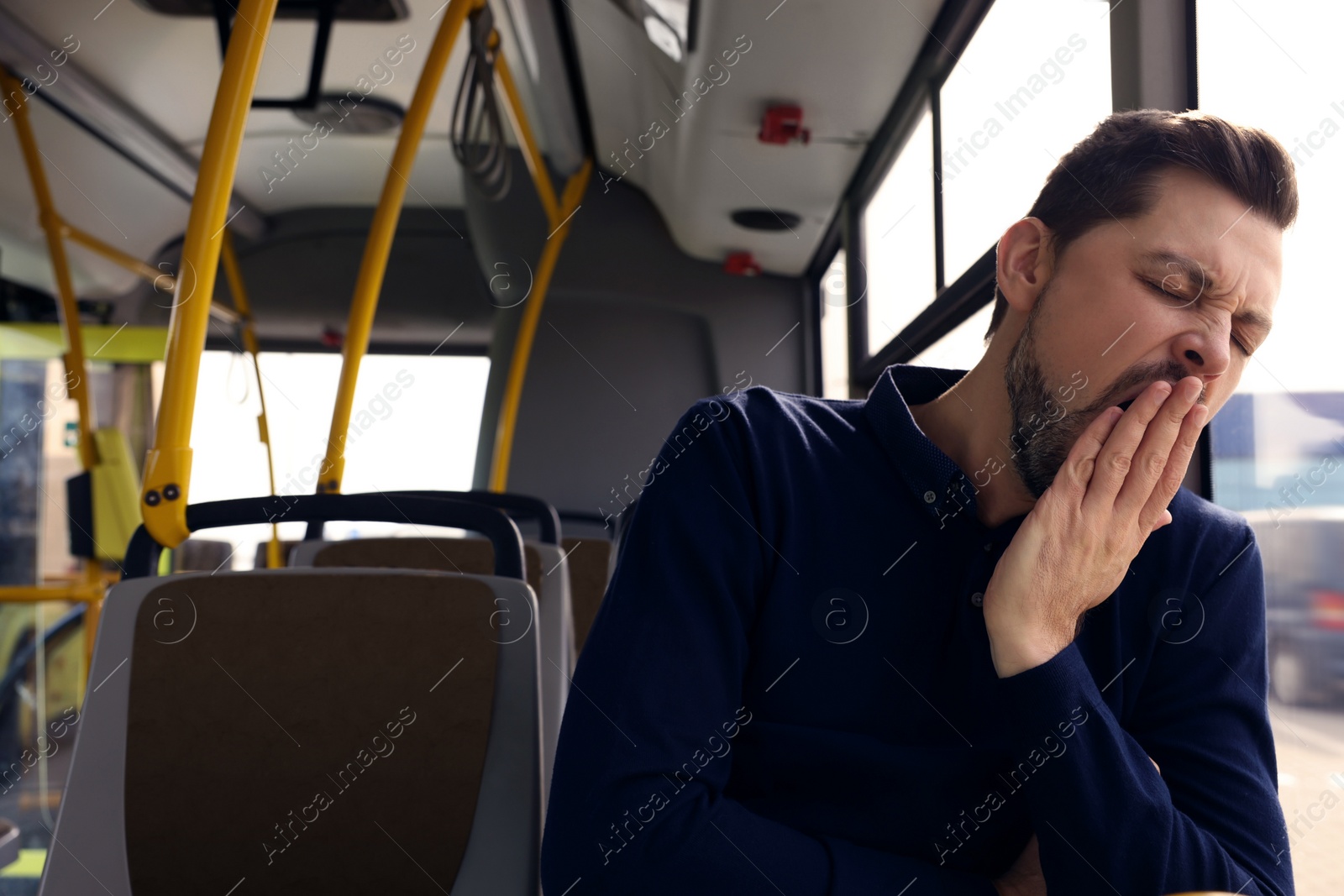 Photo of Sleepy tired man yawning in public transport