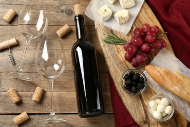 Photo of Flat lay composition with red wine and snacks on wooden table