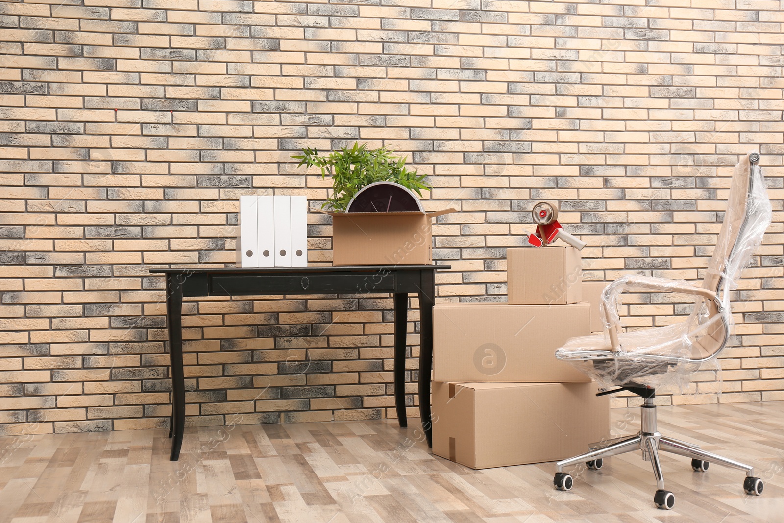 Photo of Furniture and moving boxes in empty office