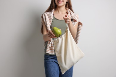 Woman with eco bag and pear on white background