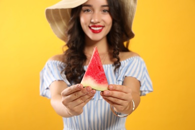Photo of Beautiful young woman against yellow background, focus on hands with watermelon