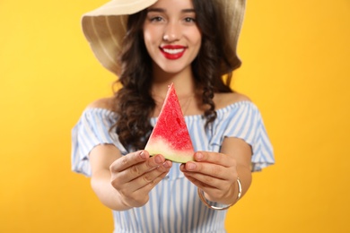 Beautiful young woman against yellow background, focus on hands with watermelon