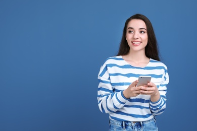 Photo of Young woman using phone on color background