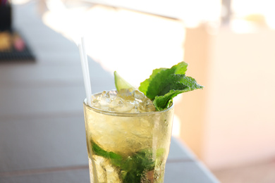 Glass of delicious mojito outdoors, closeup. Refreshing drink