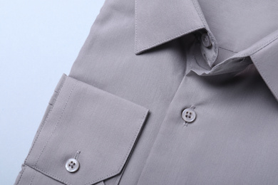 Stylish grey shirt on white background, closeup. Dry-cleaning service