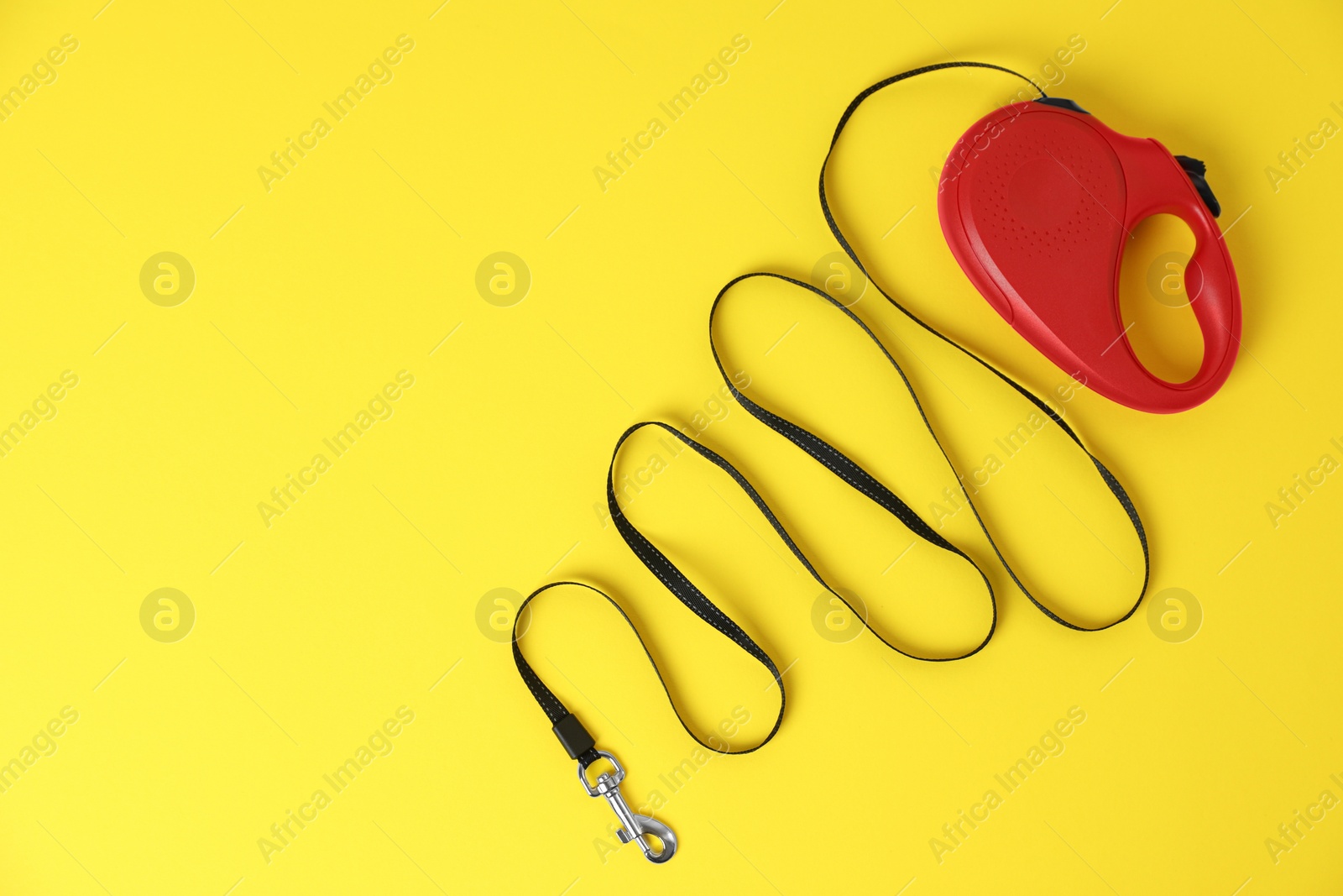 Photo of Red dog retractable leash on yellow background, top view. Space for text