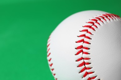 Photo of One baseball ball on green background, closeup. Space for text