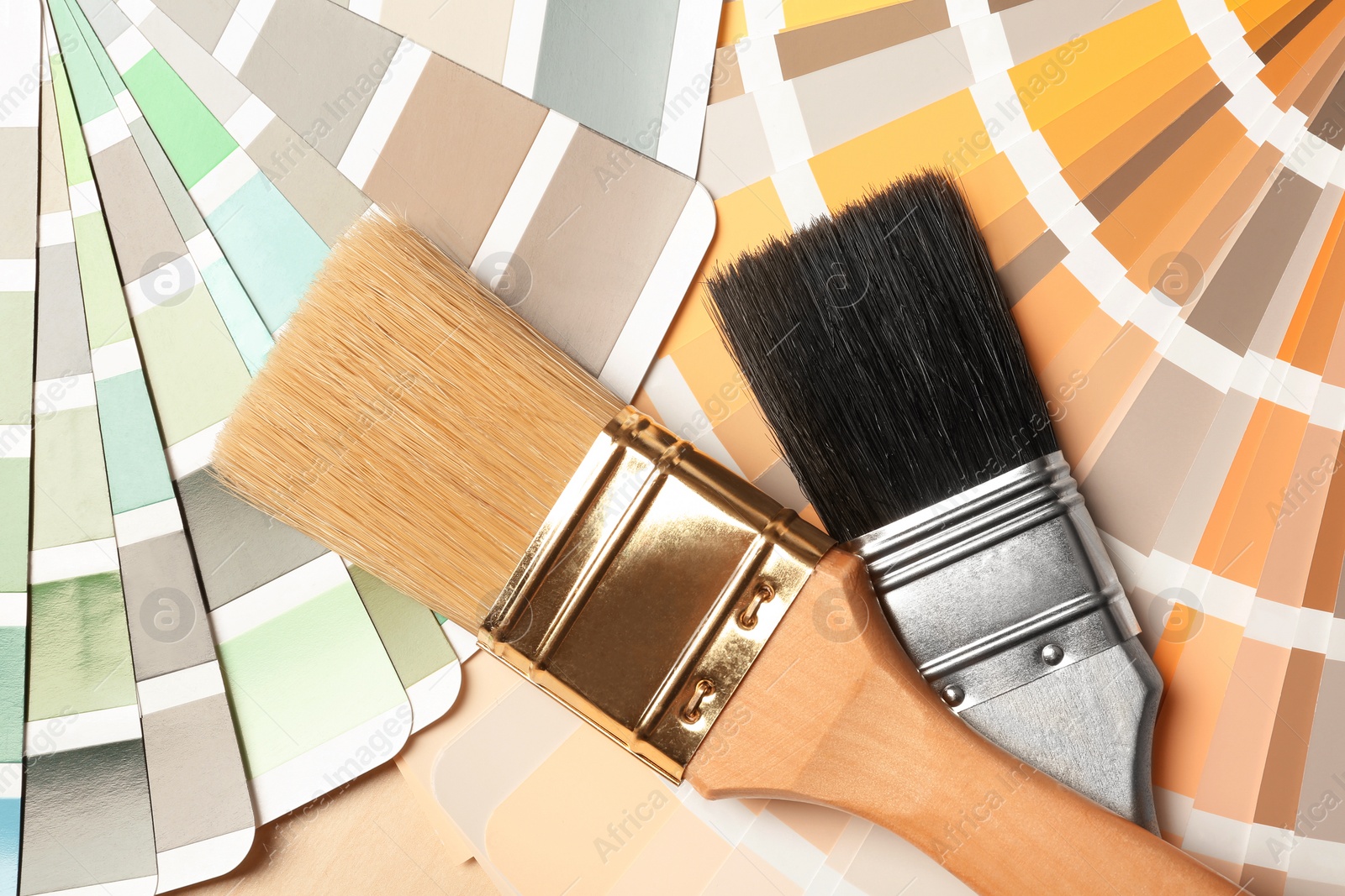 Photo of Paint brushes on color palettes, top view
