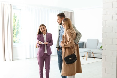 Photo of Female real estate agent working with couple in room