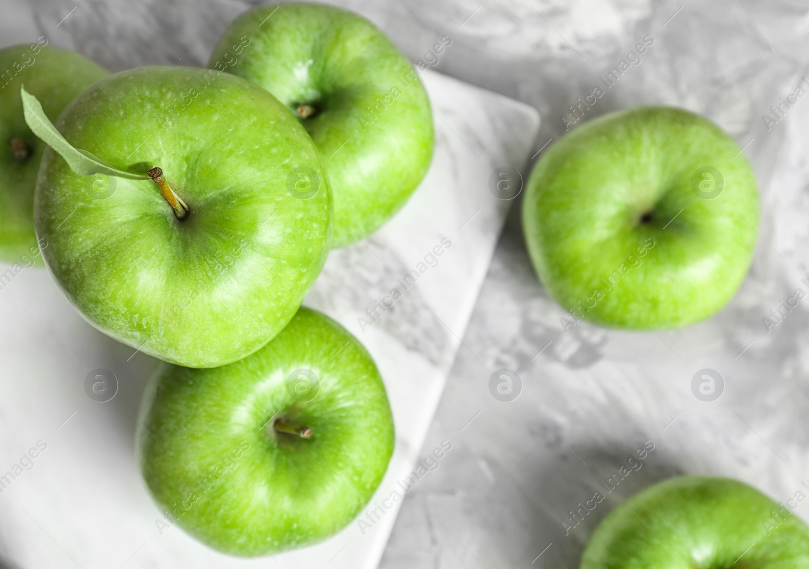 Photo of Marble board with fresh green apples on table, top view