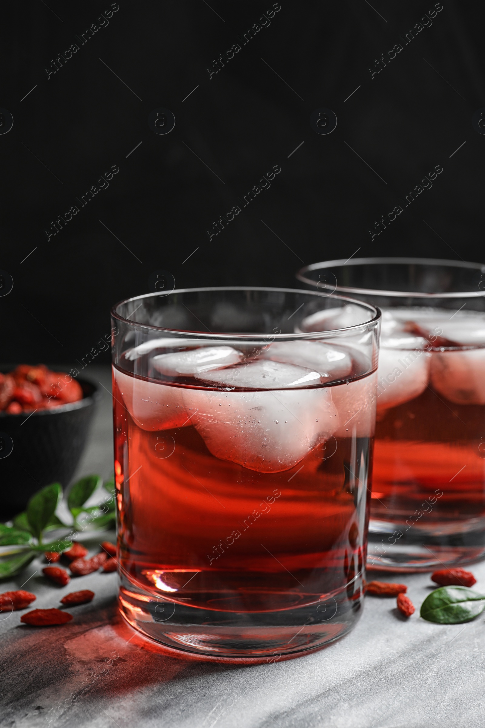 Photo of Healthy goji juice with ice in glasses on table