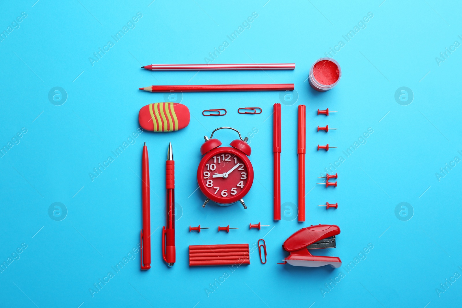 Photo of Red school stationery on light blue background, flat lay