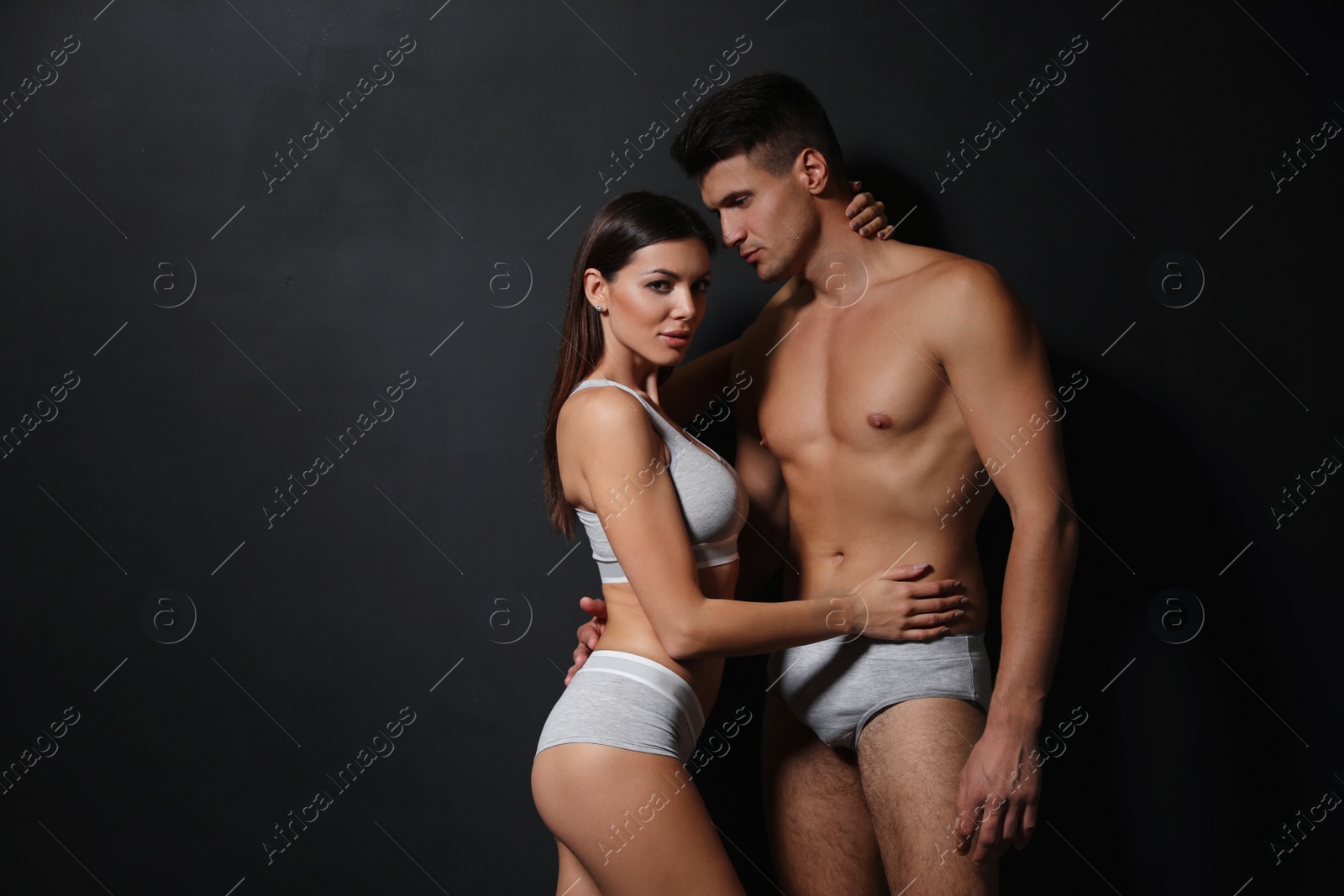 Photo of Young couple wearing underwear on black background