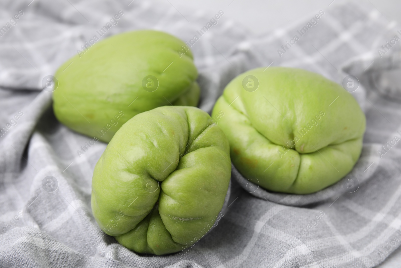 Photo of Fresh green chayote on gray napkin, closeup