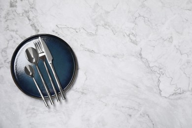 Photo of Stylish setting with elegant cutlery on white marble table, top view. Space for text