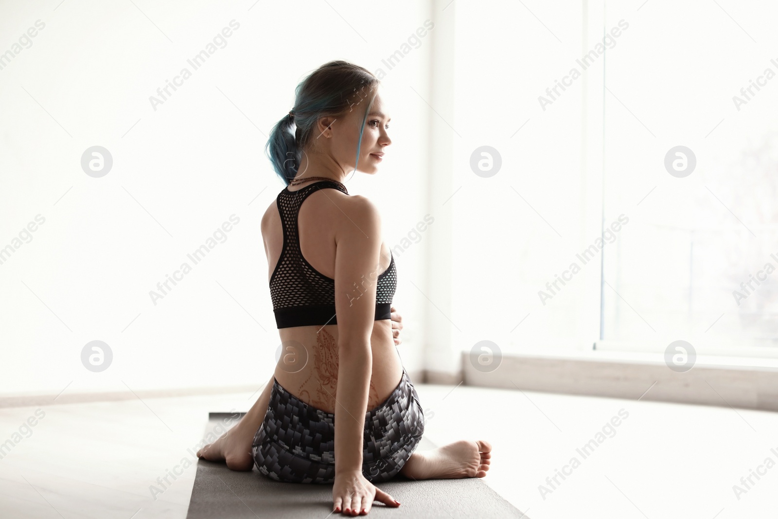 Photo of Young woman practicing yoga indoors