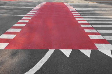 Photo of Part of bicycle lane painted red along pedestrian crossing on road