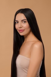 Beautiful woman with long hair on beige background