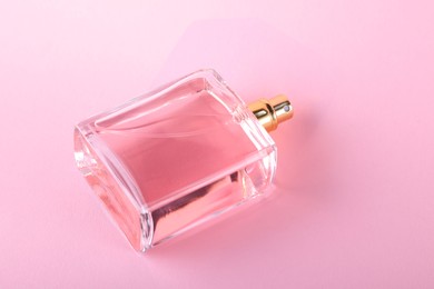 Photo of Luxury women's perfume in bottle on violet background