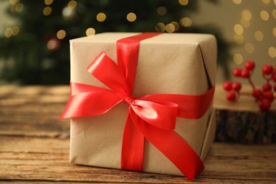 Photo of Beautiful gift box on wooden table, closeup. Christmas celebration