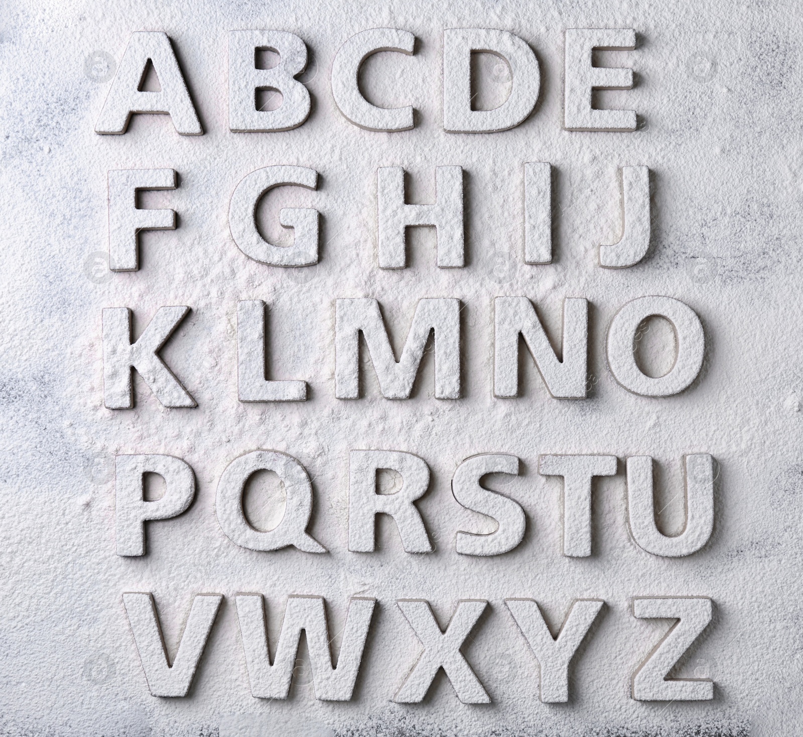 Photo of Floured alphabet letters on grey background