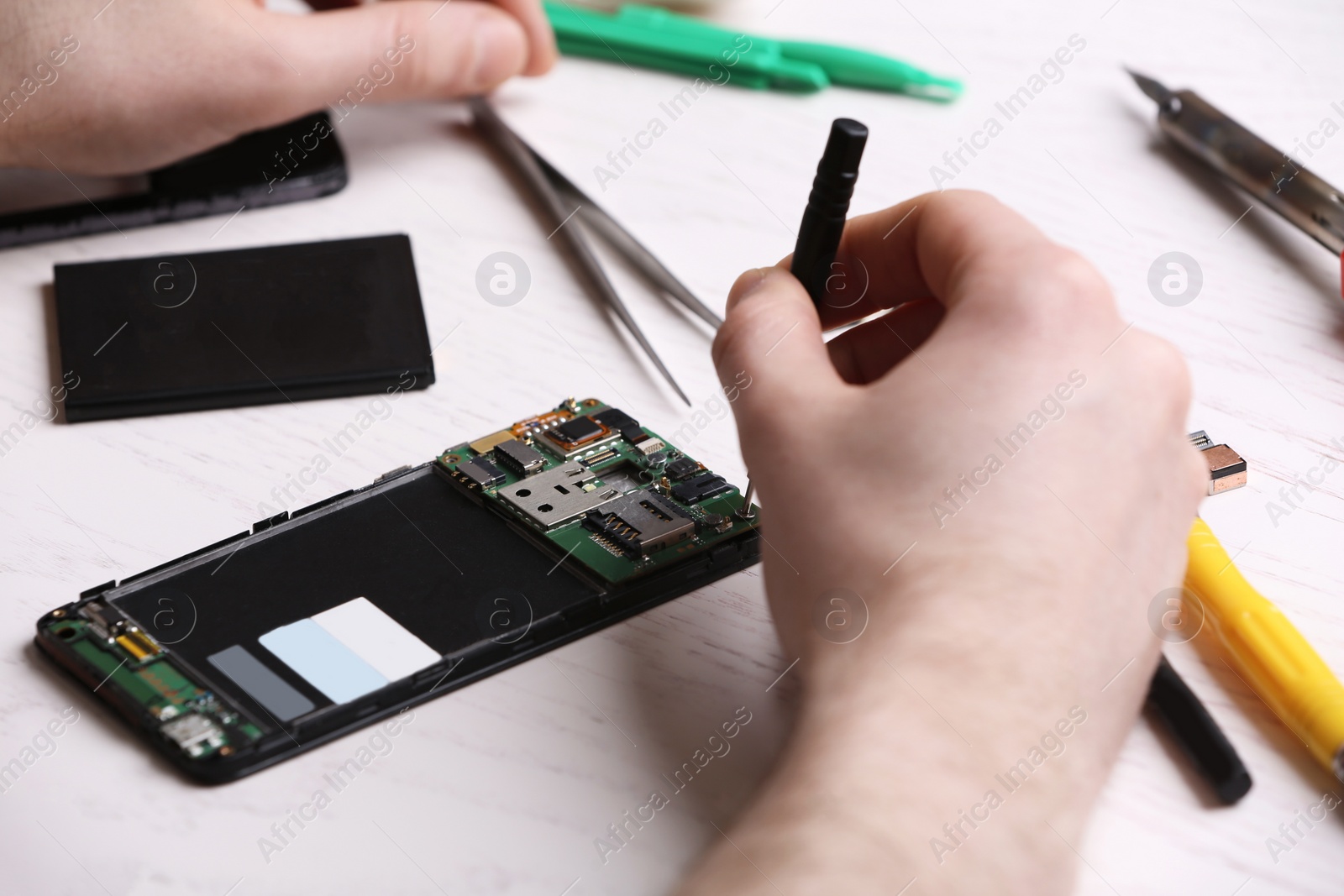 Photo of Technician fixing mobile phone at table, closeup. Device repair service