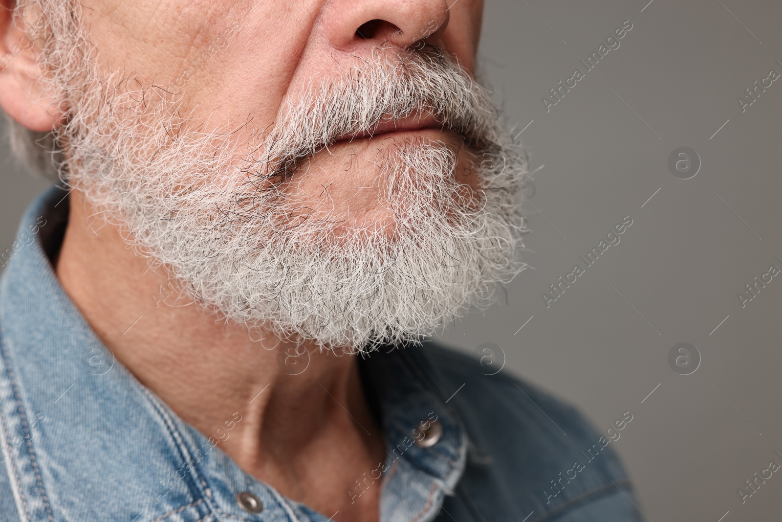 Photo of Man with mustache on grey background, closeup