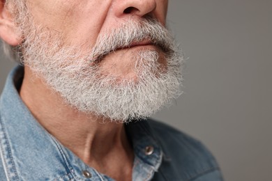 Photo of Man with mustache on grey background, closeup