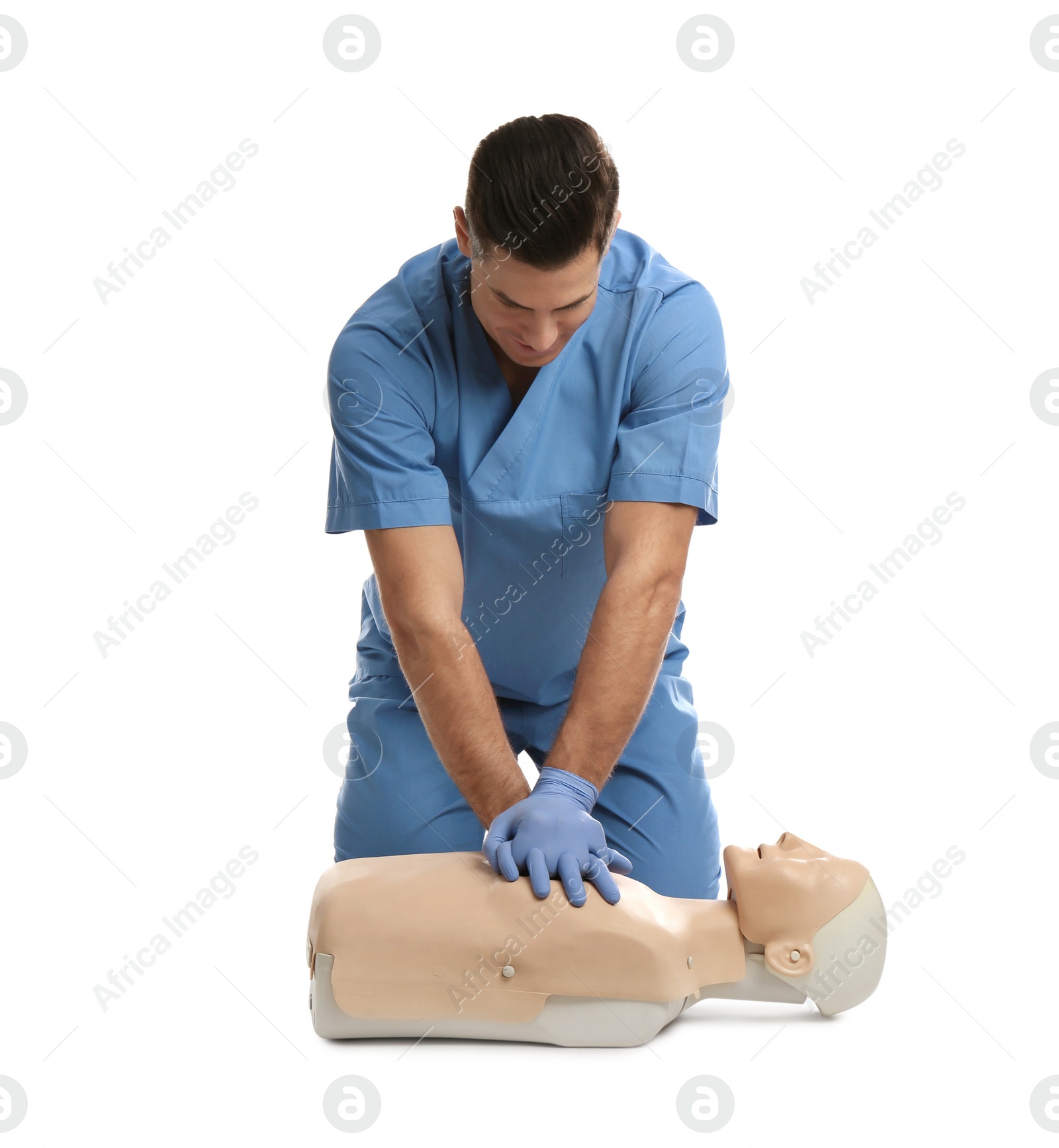 Photo of Doctor in uniform practicing first aid on mannequin against white background