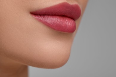 Photo of Young woman with beautiful full lips on light background, closeup