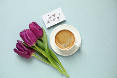 Delicious coffee, flowers and card with GOOD MORNING wish on light background, flat lay