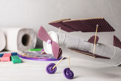 Photo of Toy plane made of toilet paper hub on white wooden table