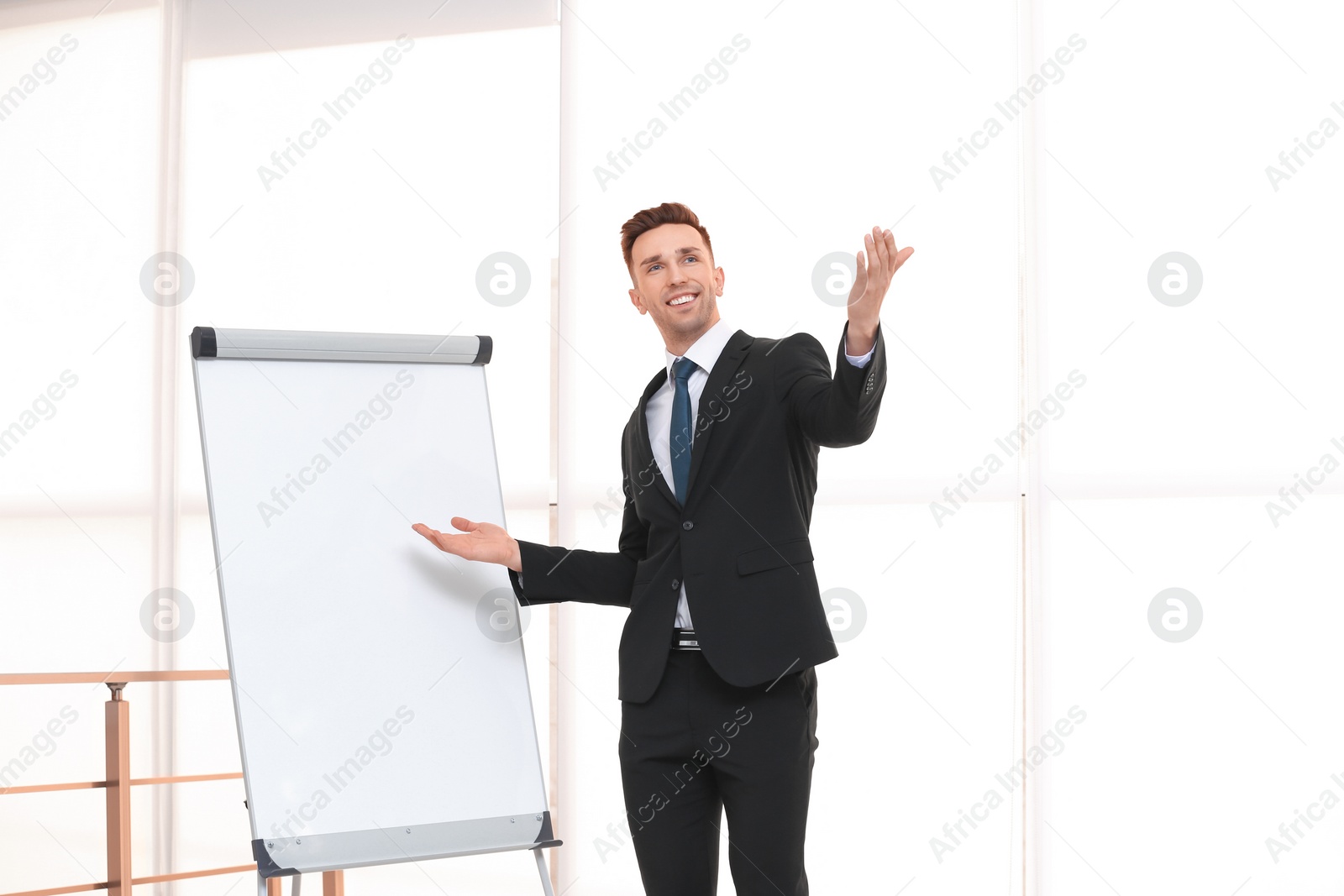 Photo of Young business trainer near flip chart, indoors