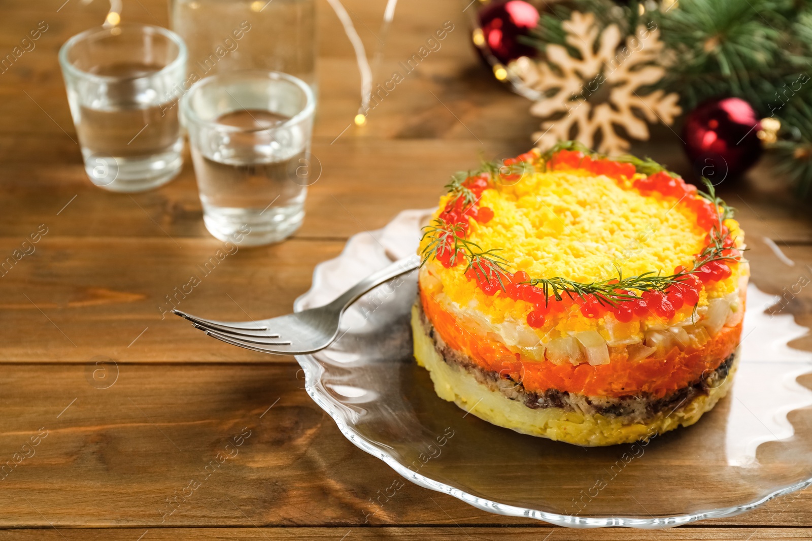 Photo of Traditional russian salad Mimosa and festive decor on wooden table