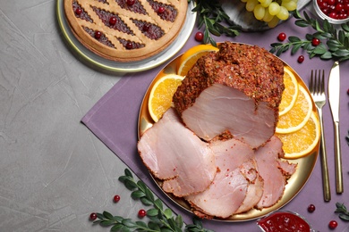 Flat lay composition with delicious ham for Christmas dinner on grey table