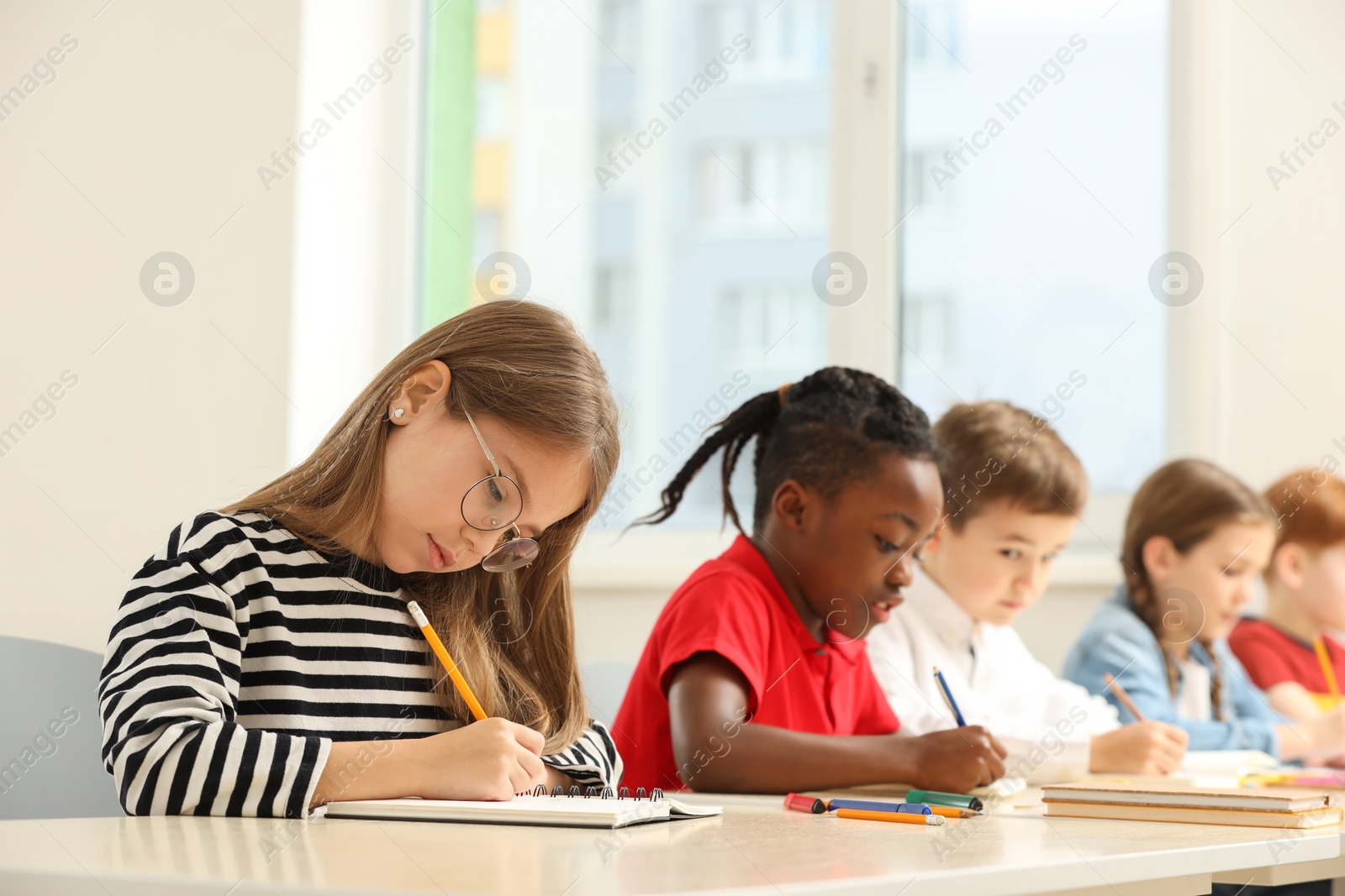 Photo of Cute children studying in classroom at school