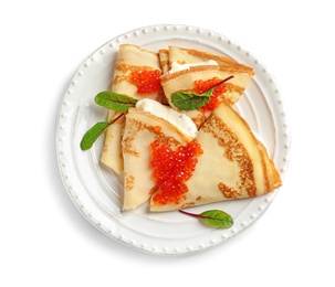 Photo of Thin pancakes with red caviar on plate against white background, top view