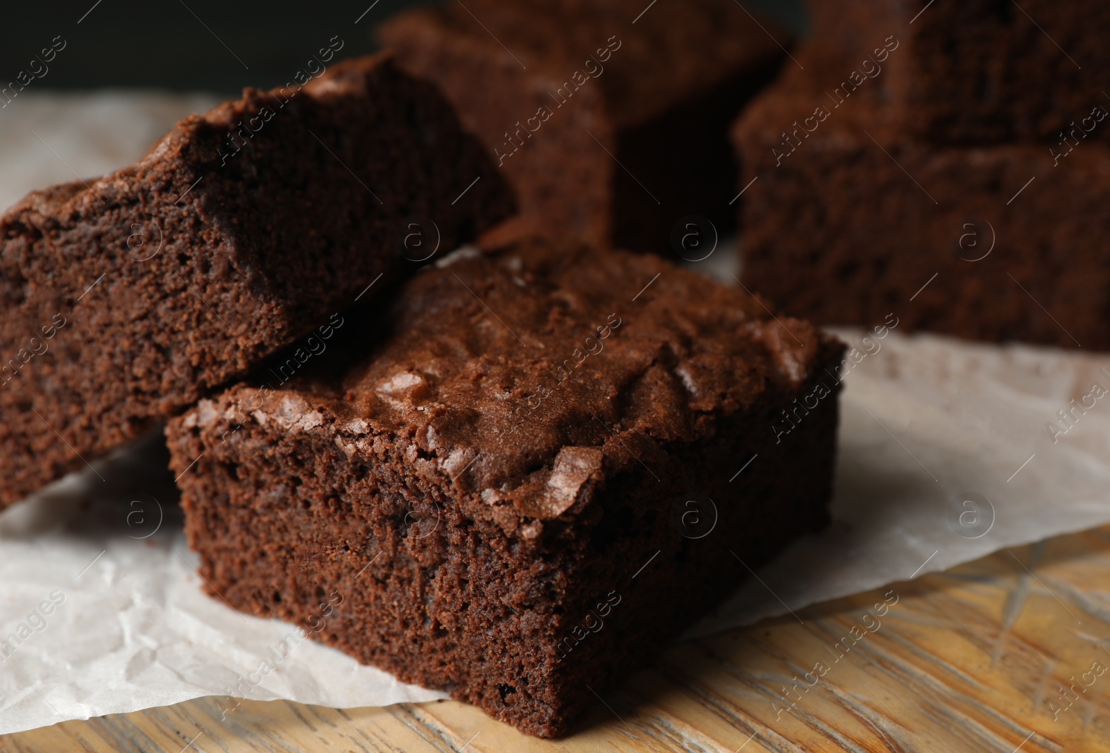 Photo of Fresh brownies on wooden board, closeup. Delicious chocolate pie