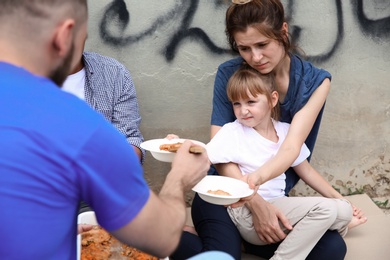 Photo of Poor people receiving food from volunteer outdoors