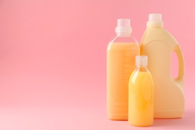 Bottles of laundry detergents on pink background. Space for text