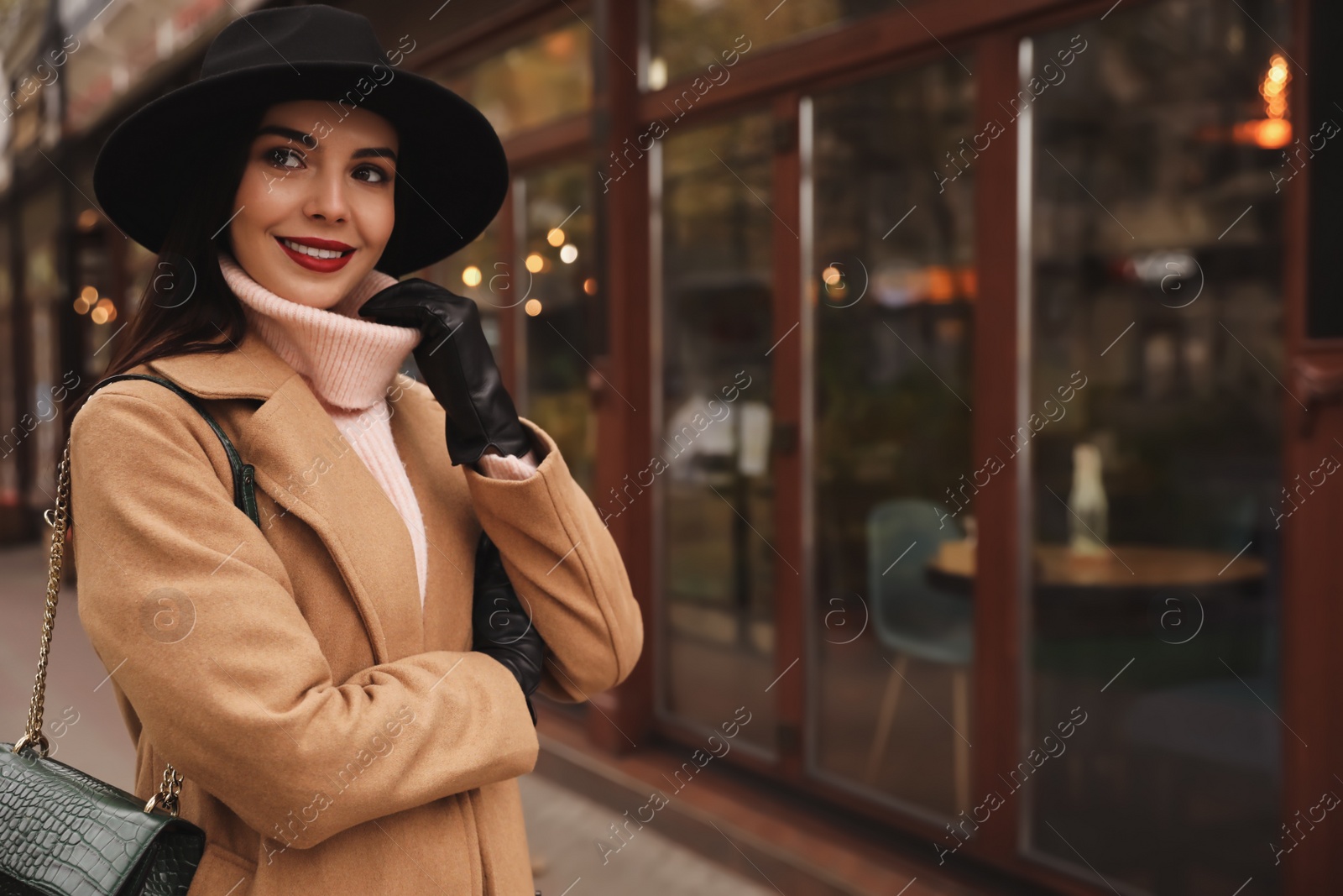 Photo of Young woman wearing stylish clothes on city street, space for text. Autumn look