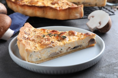 Photo of Delicious pie with mushrooms and cheese served on grey table, closeup