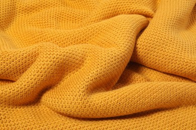 Texture of yellow knitted blanket as background, closeup