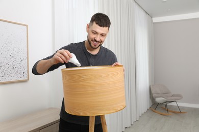 Photo of Man changing light bulb in lamp at home