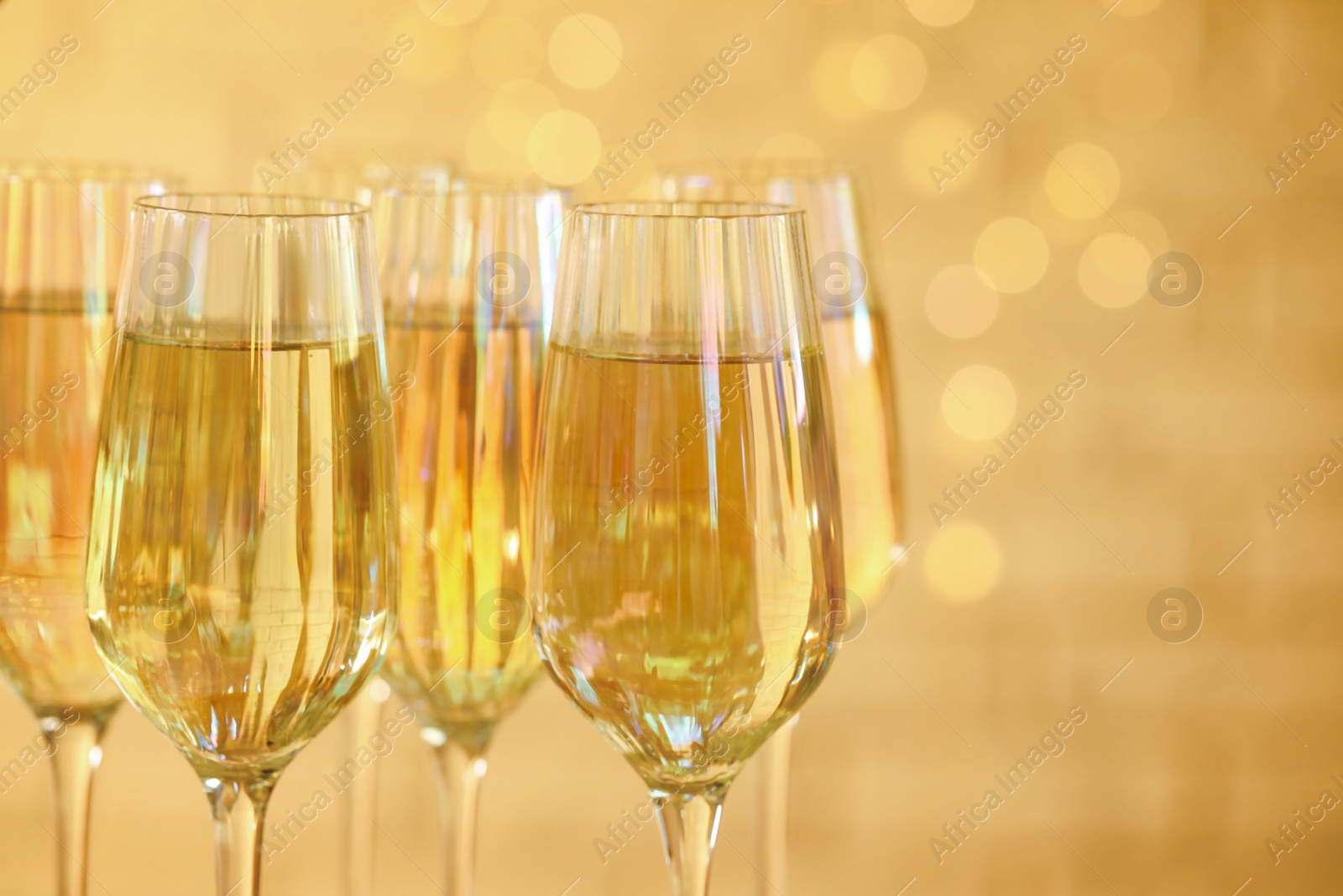 Photo of Glasses of champagne against blurred lights, closeup