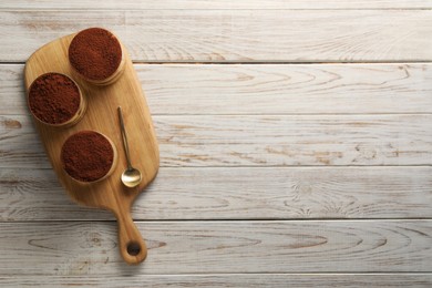 Photo of Delicious tiramisu in glasses and spoon on light wooden table, top view. Space for text