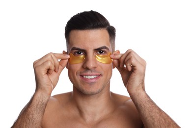 Man applying yellow under eye patches on white background