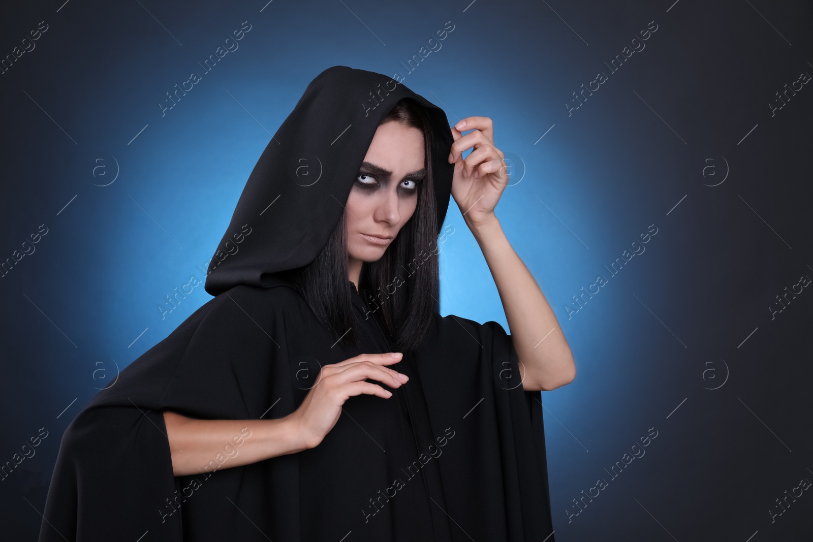 Photo of Mysterious witch with spooky eyes on color background