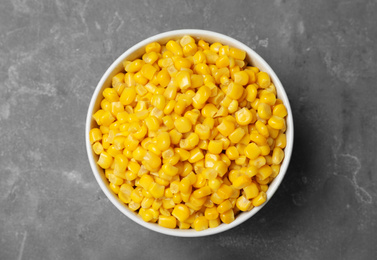 Delicious canned corn in bowl on grey table, top view