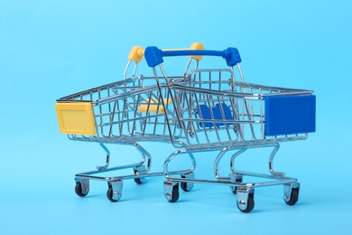 Photo of Empty shopping trolleys with handles on color background